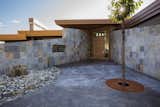 The angled walls guide traffic flow to the front door, which was custom designed and made. Below this walkway, hides a two-story garage and a private courtyard can be seen behind the iron grillwork "window".