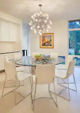 Dining room featuring owner's custom glass table and hanging chandelier.
