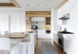 Kitchen, Laminate Counter, White Cabinet, Laminate Cabinet, Light Hardwood Floor, Wood Counter, Glass Tile Backsplashe, Ceiling Lighting, Pendant Lighting, Microwave, Wall Oven, and Drop In Sink  Photos from Résidence Léger
