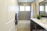 A new modern tub and natural stone and glass tile mosaic backsplashes set the tone for the guest bath.
  
Interior Design, Photos & Styling © Yoko Oda Interior Design, LLC
