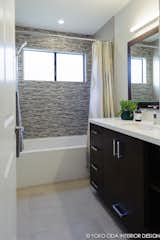 A new modern tub and natural stone and glass tile mosaic backsplashes set the tone for the guest bath.
  
Interior Design, Photos & Styling © Yoko Oda Interior Design, LLC