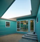 A tiny courtyard painted in the owners' favorite color: aqua.  This little space will serve the dog and cat she intends to adopt in the future.