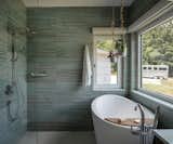 The primary bathroom has a zero threshold shower and an Ofuro (Japanese soaking tub).  Outside, the owner's horse trailer can be seen parked by the edge of the drive.