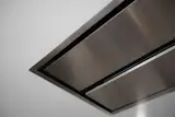 Minimal range hood is flush with ceiling.