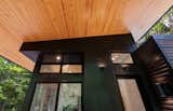 Front porch features Pine-clad ceiling with uplighting and black metal cladding.