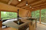 Kitchen, Concrete Counter, Medium Hardwood Floor, Ceiling Lighting, Cooktops, Wall Oven, Dishwasher, and Undermount Sink  Photo 7 of 11 in Sleep in This Romantic Tree House Just Outside NYC