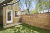 Outdoor, Hanging Lighting, Wood Fences, Wall, Horizontal Fences, Wall, Small Patio, Porch, Deck, Wood Patio, Porch, Deck, Trees, Back Yard, and Grass  Photo 2 of 10 in This Architect’s Tiny Studio Is the Ultimate Backyard Workspace