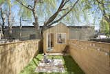 Outdoor, Back Yard, Grass, Trees, Small Patio, Porch, Deck, Wood Patio, Porch, Deck, Horizontal Fences, Wall, Hanging Lighting, and Wood Fences, Wall  Photo 10 of 10 in This Architect’s Tiny Studio Is the Ultimate Backyard Workspace