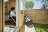 Outdoor, Trees, Grass, Small Patio, Porch, Deck, Wood Patio, Porch, Deck, Horizontal Fences, Wall, Wood Fences, Wall, Hanging Lighting, and Back Yard  Photo 8 of 10 in This Architect’s Tiny Studio Is the Ultimate Backyard Workspace