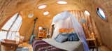 Bedroom, Bookcase, Night Stands, Bed, Pendant, Medium Hardwood, Chair, and Rug  Bedroom Medium Hardwood Pendant Bookcase Chair Photos from Soak Up the Magic of Patagonia at This Eco-Friendly Geodesic Dome Retreat
