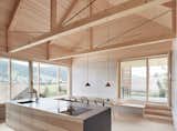 Dining, Pendant, Chair, Table, Bench, and Light Hardwood Exposed trusses celebrate the home's timber construction.  Dining Bench Light Hardwood Pendant Chair Photos from A Minimalist Home Is Built Into Steep Terrain in an Austrian Valley