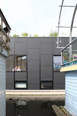 Exterior, Metal Siding Material, Boathouse Building Type, and Flat RoofLine Ducks swim close to the windows.  Photos from An Architect Creates a Two-Level Houseboat For His Family on a Tight Budget