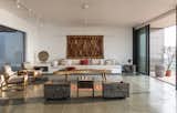Living Room, Track Lighting, Pendant Lighting, Coffee Tables, Sofa, Chair, End Tables, and Rug Floor A tree-stump end table adds a dose of organic style to the modern living area.

  Photos from A Modern Home in India Evokes Emotion With a Giant 4-Ton Rock