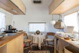 Dining Room, Table, Chair, Pendant Lighting, Rug Floor, and Medium Hardwood Floor The Merchant on the Road Airstream interior was curated by the mother/daughter duo of Merchant Modern.  Photo 9 of 16 in Joshua Tree Is Now Home to a Chic Airstream Oasis—Featuring 4 Trailers Available to Rent
