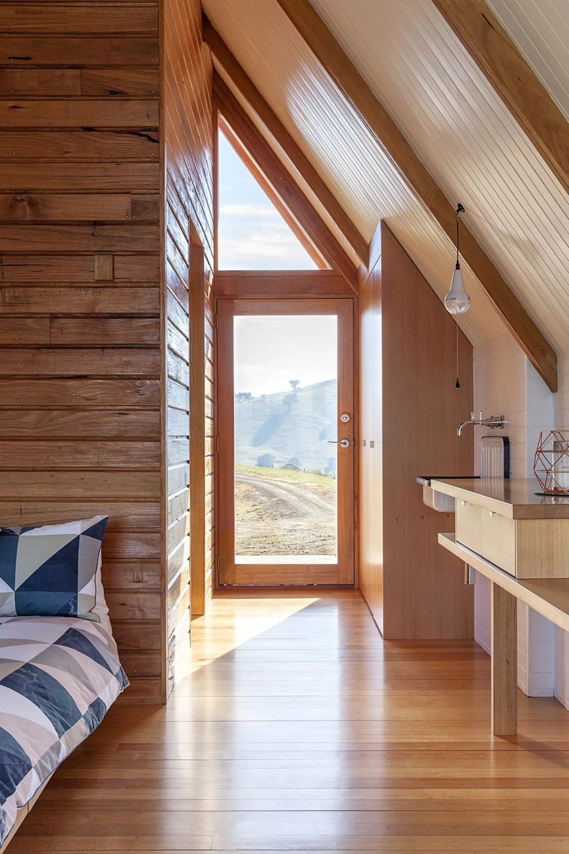 The Silvertop Ash sloped walls contrasts with the v-groove pine that wraps around the bathroom.