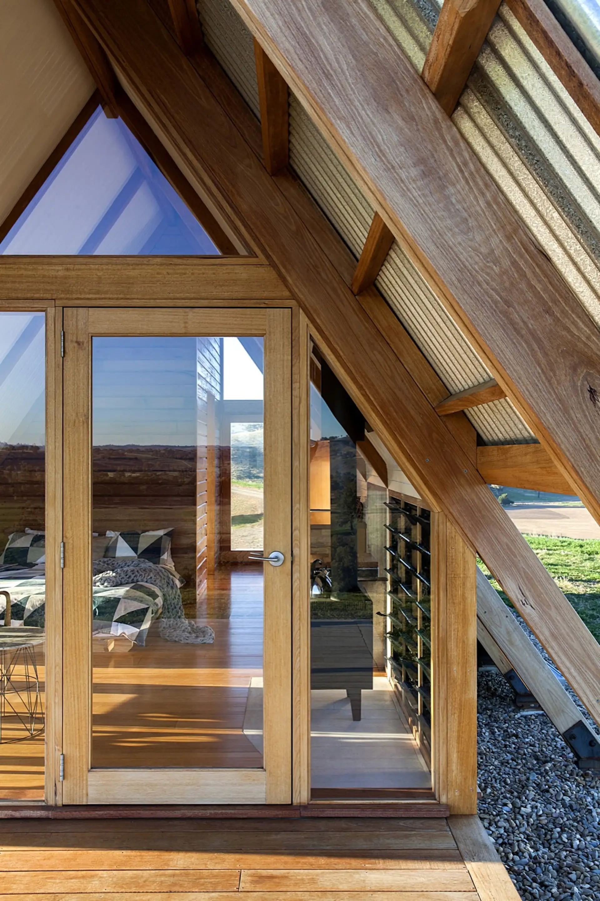 The glazed door, along with other openings, allow guests to enjoy sunset views from bed.