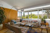 Living Room, Chair, Sofa, Floor Lighting, Medium Hardwood Floor, Coffee Tables, and Rug Floor An Arco floor lamp ties the great room together.   Photo 2 of 15 in Calling All Richard Neutra Fans—His Bonnet House in L.A. Hits the Market at $1.8M