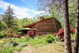 Shielded from the street, the two-bedroom, two-bath home is set on a 10-acre property with gardens, lawns, and old-growth trees overlooking Honey Creek.  