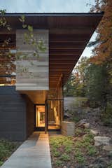 The rich material palette of stone, timber, glass, and board-formed concrete blend the home into the surroundings. 