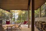Positioned for stellar outdoor views, the screened porch features concrete floors, a cedar ceiling, natural fir posts, and midcentury chairs. 