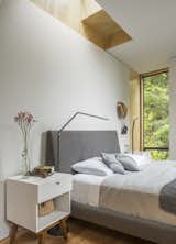 The bedroom is illuminated by tall, skinny windows and a skylight that's positioned over the bed for stargazing. 