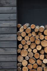 Firewood is neatly stacked in a built-in storage space on the south side of the home. 