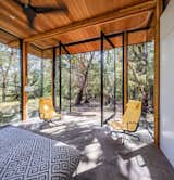 The master bedroom is enclosed in glass, and connects to the outdoors via massive pivot doors. 