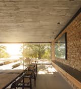 Dining Room, Recessed Lighting, Concrete Floor, Chair, and Table Brick was also used in the interior to lend a sense of warmth.  Photo 7 of 16 in An Expansive Grass Roof Tops This Modern Brazilian Home