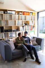 Living Room, Storage, Sofa, Concrete Floor, and Bookcase Scott Mooney and Lauren Shumaker sitting on their living room couch purchased from a local business, Perch Furniture.  Photo 5 of 20 in Budget Breakdown: A Portland Couple Design and Build a Compact Home For $222K