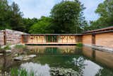This Striking Net-Zero Home Wraps Around a Serene Pond