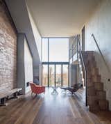 The interior boasts an industrial aesthetic achieved by the exposed brick wall, concrete surfaces, and copper finishes.

