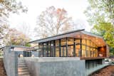 Exterior, House Building Type, Concrete Siding Material, Wood Siding Material, and Glass Siding Material The "living pavilion" on the southern wing is elevated to make the space level with the home.

  Photos from An Elegant Abode Embraces Nature Without Waiving Privacy