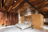 Bedroom, Porcelain Tile Floor, Wall Lighting, Bed, Wardrobe, Recessed Lighting, Storage, and Night Stands A look at the master bedroom, which unlike the other rooms in the home, features Ipe wood for both the ceiling and walls.

  Photos from A Modern Mexican Home Rises With Vertical Timber Cladding
