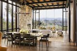 Dining Room, Table, Pendant Lighting, Standard Layout Fireplace, Rug Floor, and Medium Hardwood Floor Full-height glazing ushers in incredible views of the hills to the south.   Search “glazing” from Glass and Stone Combine to Dazzling Effect on California's Central Coast