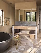 Modern bathroom fixtures are paired with rustic, natural materials. 