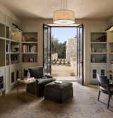 Office, Rug Floor, Shelves, Light Hardwood Floor, Chair, and Library Room Type The library overlooks the courtyard and the two guest bedrooms.   Photo 4 of 15 in Glass and Stone Combine to Dazzling Effect on California's Central Coast