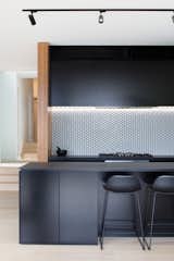 In this kitchen with matte black cabinets, elegant Perini Monroe ceramic tiles line the kitchen backsplash. 