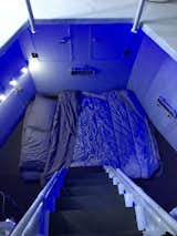 Bedroom, Wall Lighting, Bed, and Storage A queen-size bed is located down below and accessible via ship ladder.  Photo 15 of 17 in A Lunar Lander-Inspired Tiny House is an Otherworldly Escape