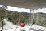 A deep roof overhang creates a sheltered outdoor patio for enjoying north-facing views of the landscape. 