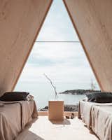 Bedroom, Night Stands, Bed, Light Hardwood Floor, and Table Lighting The triangular window is made from polycarbonate, which was chosen for safety reasons.

  Photo 3 of 10 in An A-Frame Cabin Celebrates the Zero-Emission Lifestyle in Finland