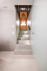 The concrete staircase that leads to the basement is illuminated with LED strips. 