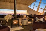 The cozy lounge with a wood-burning stove overlooks views of the northern rocky hills.