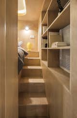 Bedroom, Shelves, Bed, Medium Hardwood, Table, and Wall The second staircase is skinnier and sandwiched between the bed and window.

  Bedroom Bed Table Wall Photos from Rotated Volumes Cleverly Maximize Space in a Tiny Shanghai Apartment