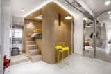 Bedroom, Ceiling, Chair, Bed, Storage, Pendant, and Concrete The bed is flanked by two staircases, one of which is hidden behind a white curtain. Hidden storage is integrated into the stair design.  Bedroom Storage Chair Concrete Pendant Photos from Rotated Volumes Cleverly Maximize Space in a Tiny Shanghai Apartment