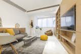 Living Room, Concrete Floor, Coffee Tables, Chair, Recessed Lighting, Sofa, Shelves, and Rug Floor A large window at the end of the living space lets in ample natural light.   Photo 5 of 17 in Rotated Volumes Cleverly Maximize Space in a Tiny Shanghai Apartment
