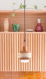 Refurbished vintage copper pendant lights hang above the kitchen’s handmade Manuka honey-colored tiles. 