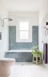 Bath Room, Two Piece Toilet, Porcelain Tile Floor, Stone Counter, Ceramic Tile Wall, Alcove Tub, Vessel Sink, and Enclosed Shower Handmade fish-scale tiles line the wall over the bath.  Photos from A Cramped Bungalow Is Reborn as an Eco-Minded Home for Two Gardeners