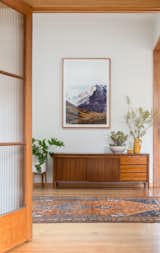 Office, Storage, Medium Hardwood Floor, Study Room Type, and Rug Floor A view from the lounge into the converted study furnished with a vintage midcentury sideboard.  Photo 5 of 15 in A Cramped Bungalow Is Reborn as an Eco-Minded Home for Two Gardeners