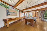 Living Room, Medium Hardwood Floor, and Chair Next to the bar, a billiards room branches off of the circular Great Room and leads to a cozy den.  Photo 9 of 22 in Jackie Gleason’s Spaceship-Like Mansion Hits the Market For $12M