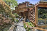 Exterior, Metal Roof Material, House Building Type, Wood Siding Material, and Glass Siding Material Here's the entrance to The Mothership, which is flanked by lush landscaping.

  Photo 4 of 22 in Jackie Gleason’s Spaceship-Like Mansion Hits the Market For $12M